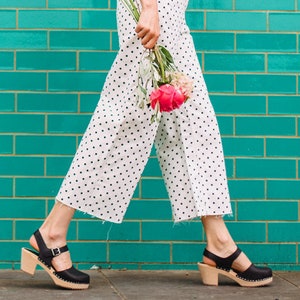 Black leather clogs. Highwood black womens clogs on a natural wooden clogs base.