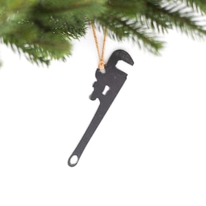 May include: A black metal wrench shaped Christmas ornament with a brown twine hanger.