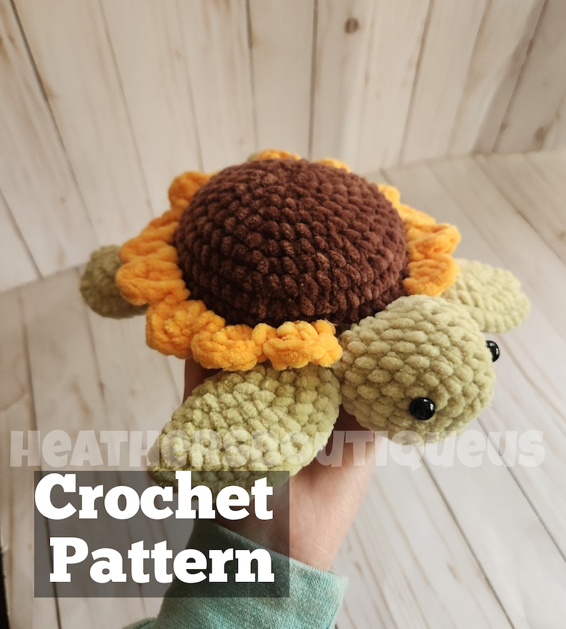 May include: Crochet pattern for a sunflower turtle amigurumi toy. The turtle is made with brown, yellow, and green yarn. The turtle has black eyes and a brown shell with a yellow sunflower.