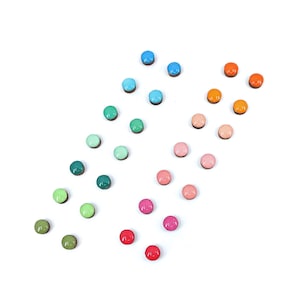 May include: Assortment of colorful round buttons in various shades of blue, green, pink, orange, and red. The buttons are arranged in a rainbow pattern.