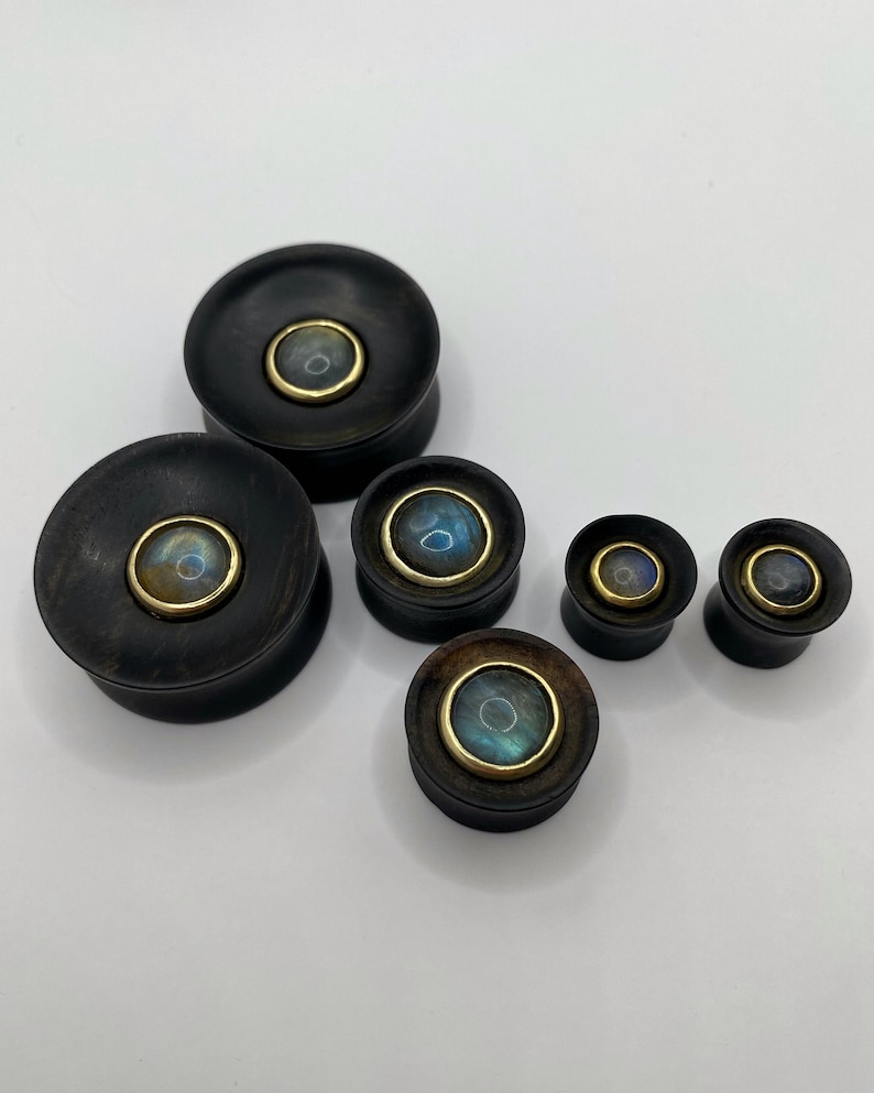 Concave ebony wood plugs with labradorite inlay. Labradorite cabochons of these ebony concave plugs are set in brass bezels. Can be made in sizes from 10mm to 30mm. Each labradorite cabochon inlay is unique