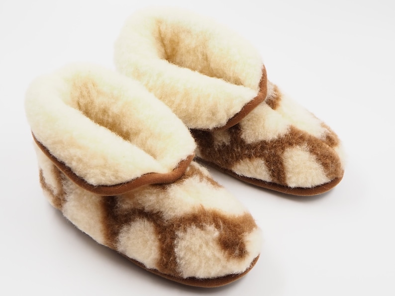 May include: A pair of brown and white wool slippers with a fuzzy lining. The slippers have a geometric pattern.