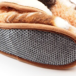 May include: Close-up of the bottom of a brown and white patterned slipper with a gray textured sole.