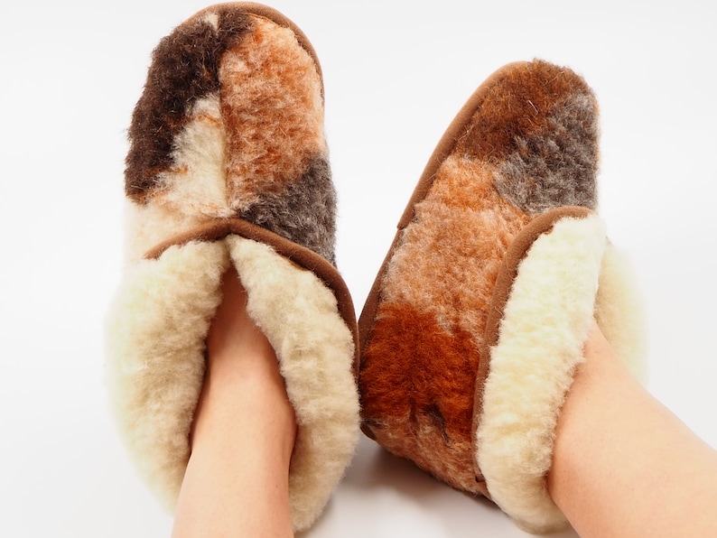 May include: A pair of brown and white sheepskin slippers with a soft, fluffy interior.