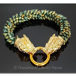 May include: A green and gold beaded bracelet with two gold dragon head clasps. The bracelet is made of small, faceted beads and has a twisted design.