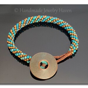 May include: A turquoise and gold beaded bracelet with a copper button closure. The bracelet is handmade and features a unique spiral design.