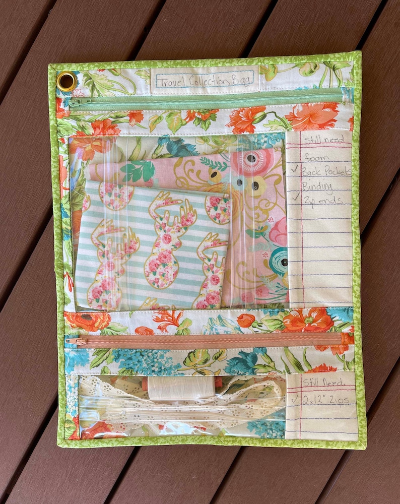 May include: A green and floral fabric zippered pouch with clear plastic pockets. The pouch is labeled "Travel Collection Bag" and has a handwritten list of items needed for the project, including "foam", "back pockets", "binding", and "zip ends".