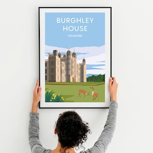 May include: A framed illustration of Burghley House in Stamford, England. The illustration features a large, white building with a green lawn and two deer in the foreground. The text "Burghley House" and "Stamford" is printed in black at the top of the illustration.