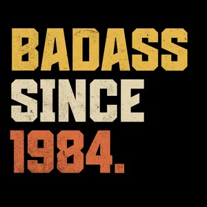 May include: A graphic design on a black background featuring the text BADASS SINCE 1984. The word BADASS is in yellow, SINCE is in white, and 1984 is in orange. Each line of text uses a bold, blocky, distressed font with a vintage aesthetic.