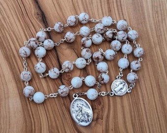 May include: White and brown marbled rosary beads with a silver St. Anthony medal.