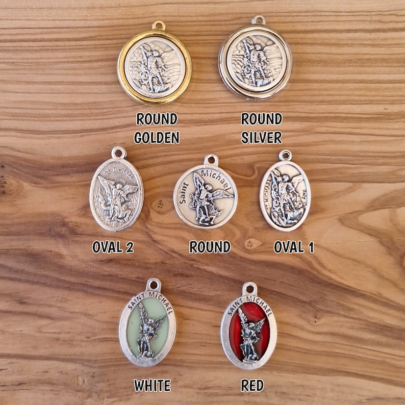 May include: Six different Saint Michael medallions, each with a different color and design. The medallions are round and oval shaped, with a silver finish. The medallions feature a depiction of Saint Michael, the archangel, with a sword and shield. The medallions are labeled with the colors: golden, silver, oval 2, round, oval 1, white, and red.