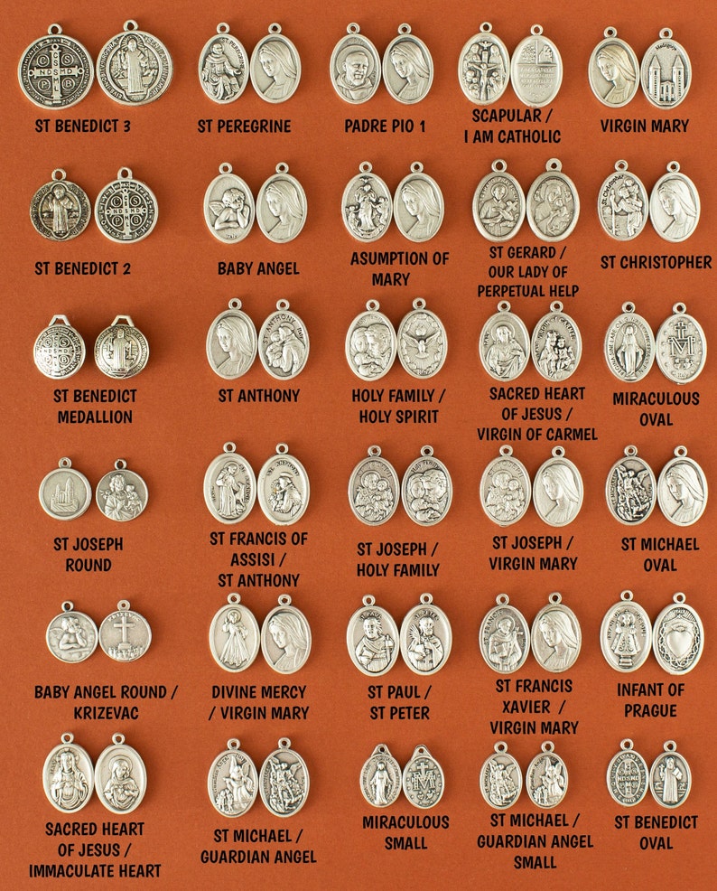 May include: A collection of 25 silver oval-shaped medallions with various religious figures and symbols. The medallions are arranged in five rows of five. Each medallion has a different image, including St. Benedict, St. Anthony, St. Joseph, St. Francis, St. Michael, the Virgin Mary, and the Sacred Heart of Jesus.