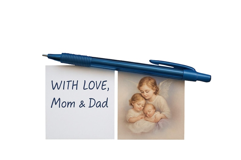 Puede incluir: Un bol&iacute;grafo azul oscuro descansa sobre dos im&aacute;genes. Una presenta el texto "WITH LOVE, Mom & Dad". La otra es una pintura de tres figuras querubinas. El fondo es blanco.