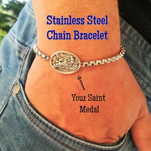 May include: Stainless steel chain bracelet with a silver oval pendant featuring a religious image. The text "Stainless Steel Chain Bracelet" and "Your Saint Medal" is visible in the image.