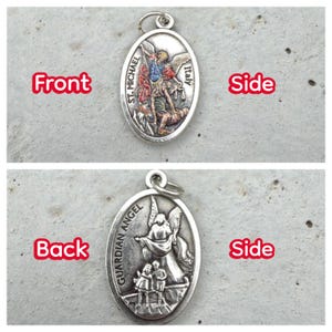 Puede incluir: Colgante ovalado de plata. El anverso muestra a San Miguel con el texto "ST. MICHAEL ITALY". El reverso representa un &aacute;ngel de la guarda con ni&ntilde;os y el texto "GUARDIAN ANGEL".