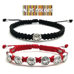 Può includere: Due braccialetti con ciondoli argentati. Un braccialetto è nero e l'altro è rosso. I ciondoli presentano un'immagine argentata di un viso umano. Il testo "IN 25 COLORS" è visualizzato sopra i braccialetti.