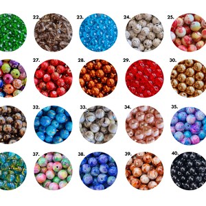 May include: Assortment of 20 different types of beads, each displayed in a circle with a number from 21 to 40. The beads are various colors, shapes, and sizes, including green, brown, blue, white, red, orange, gold, silver, pink, and black.