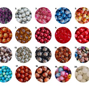 May include: Twenty different types of beads in various colors and patterns, including red, blue, white, black, and brown. The beads are arranged in a grid pattern.
