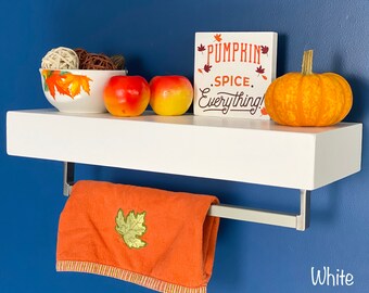 Puede incluir: Estante flotante blanco con un toallero, un cuenco de decoración de otoño, dos manzanas y un letrero que dice "Pumpkin Spice Everything!"