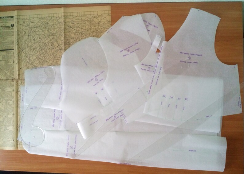 Puede incluir: Un conjunto de patrones de costura de tela blanca con marcas moradas. Los patrones son para una blusa sin mangas, una manga y un escote. El texto en los patrones dice "DIY Dress Pattern & Sewing", "Sleeveless Top", "Back Neck", "Front Neck", "Sleeve", "Back", "Front", y "Fabric Cut".