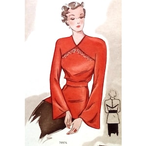May include: A red blouse with a V-neck and long sleeves. The blouse has a decorative lace trim around the neckline. The model is wearing a black skirt.