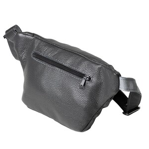 Puede incluir: Un bolso de cintura gris oscuro hecho de cuero texturizado. La bolsa presenta un cierre de cremallera negro y una correa ajustable negra. El bolso de cintura est&aacute; dise&ntilde;ado para usarse alrededor de la cintura o cruzado.