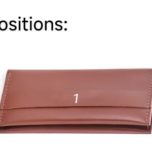 a brown leather card case with the number one on it