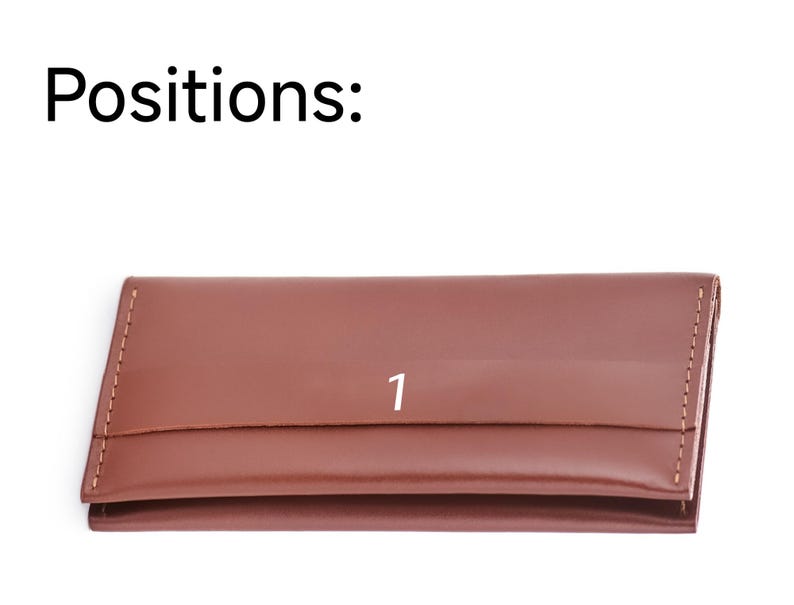 a brown leather card case with the number one on it