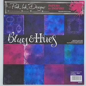 May include: A pack of 12 single-sided scrapbook paper featuring a watercolor design in shades of blue and purple. The paper is acid-free and measures 8 x 8 inches. The pack includes 12 unique designs.