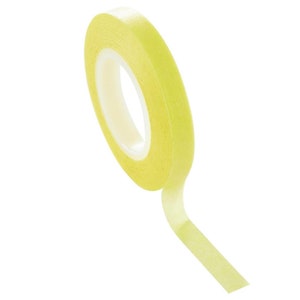 May include: A roll of yellow washi tape. The tape is rolled up and the end of the tape is hanging down.