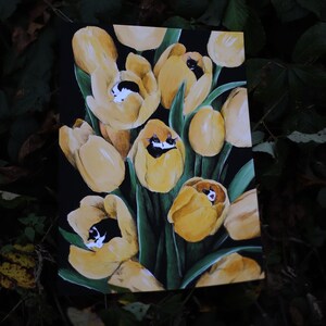 May include: A painting of yellow tulips with black and white cats peeking out from inside each flower.