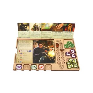 Könnte beinhalten: Ein Holzspielbrett mit einer Spielerkarte, Spielsteinen und Würfeln. Die Spielerkarte zeigt einen Mann auf einem Motorrad. Das Brett hat Felder für Spielsteine und Würfel.