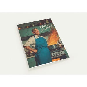 May include: A vintage-style greeting card showing a man in a blue apron smiling confidently in front of a stove with a pot on fire. The text "Chérie, je gère!" is visible.