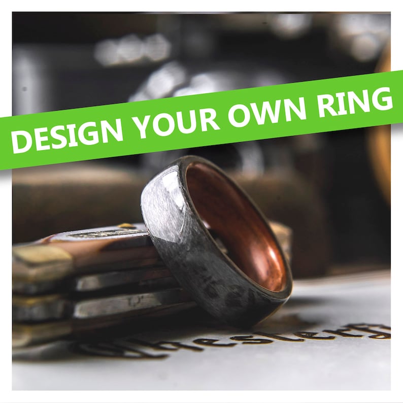 May include: A close-up of a silver and brown ring with a brushed metal finish. The ring is on a wooden surface with the text "DESIGN YOUR OWN RING" in green letters.
