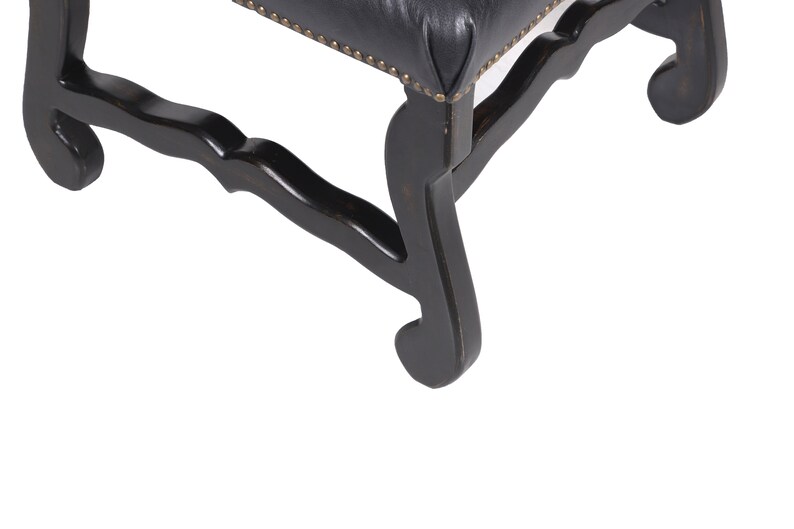 Pu&ograve; includere: Primo piano delle gambe in legno nero di una sedia con un design intagliato. Le gambe sono curve e hanno un ricciolo decorativo in basso.