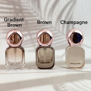 Assorted 20ml perfume bottles in different finishes (champagne gold, clear, frosted white) with rose gold caps and white spray pumps displayed.