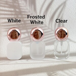 20ml perfume bottles in all available finishes (champagne gold, clear, frosted white, gradient brown) arranged side by side.