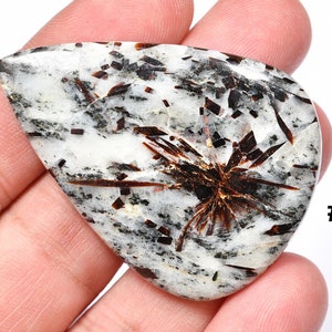 Op de afbeelding: Vier cabochon edelstenen met een witte achtergrond en zwarte en bruine insluitsels. De cabochons zijn gemarkeerd met #01, #02, #03 en #04.