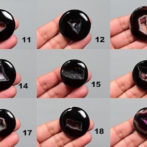 Op de afbeelding: Negen zwarte agaat cabochons met verschillende kristalinsluitsels. Elke cabochon heeft een unieke vorm en patroon. De cabochons zijn ongeveer 2,5 cm in diameter.