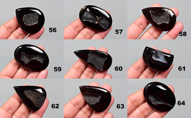 Op de afbeelding: Twaalf zwarte agaat cabochons met verschillende druzy patronen. De cabochons zijn allemaal van verschillende vormen en maten, maar ze zijn allemaal gepolijst en hebben een gladde, glanzende afwerking.