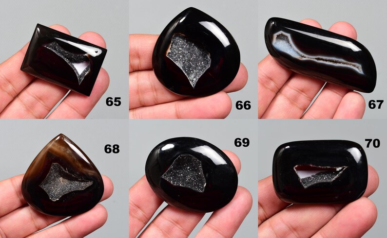 Op de afbeelding: Assortiment van tien zwarte agaat cabochons in verschillende vormen en maten. Elke cabochon heeft een uniek, natuurlijk, wit, kristallijn patroon.