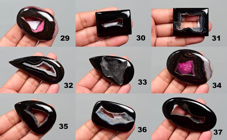 Op de afbeelding: Assortiment van negen zwarte agaat cabochons in verschillende vormen en maten. Elke cabochon heeft een uniek, natuurlijk gevormd, uitgehold centrum.