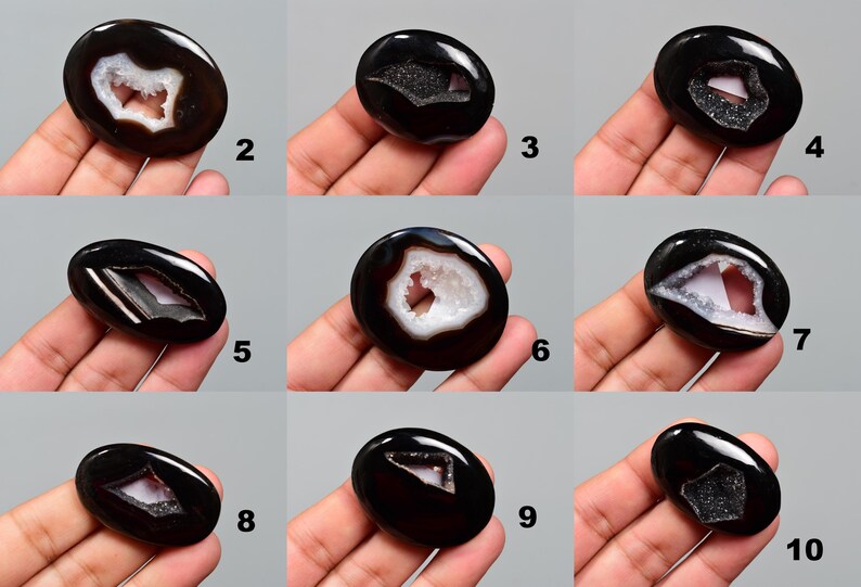 Op de afbeelding: Tien zwarte agaat cabochons met een wit druzy centrum. Elk cabochon is ovaalvormig en heeft een ander patroon van druzy.