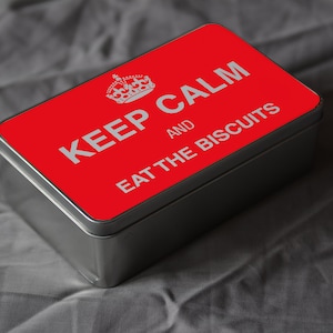 May include: A red metal tin with a white crown and the text "Keep Calm and Eat the Biscuits".
