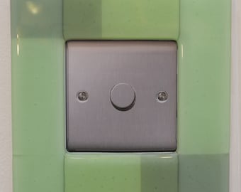 Kiln formed glass light switch surround in opaque mint green.