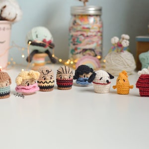 Puede incluir: Una colección de ocho personajes de Peanuts hechos a crochet, incluyendo a Charlie Brown, Snoopy, Lucy y Linus. Los personajes llevan todos diferentes atuendos y expresiones.