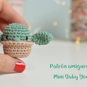 Puede incluir: Patrón de amigurumi tejido a crochet para un mini Baby Yoda. El patrón está escrito en español e incluye instrucciones para hacer un pequeño Baby Yoda verde con orejas grandes.