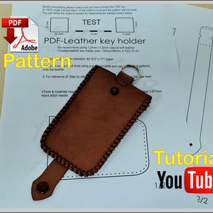 May include: A brown leather key holder pattern with stitching details. The pattern is printed on a white sheet of paper with instructions for making the key holder. The text on the paper reads "PDF-Leather key holder" and "Tutorial YouTube 2/2".