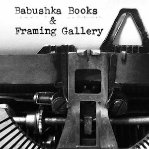 Puede incluir: Una imagen en blanco y negro de una m&aacute;quina de escribir vintage con el texto "Babushka Books & Framing Gallery" escrito en la p&aacute;gina.