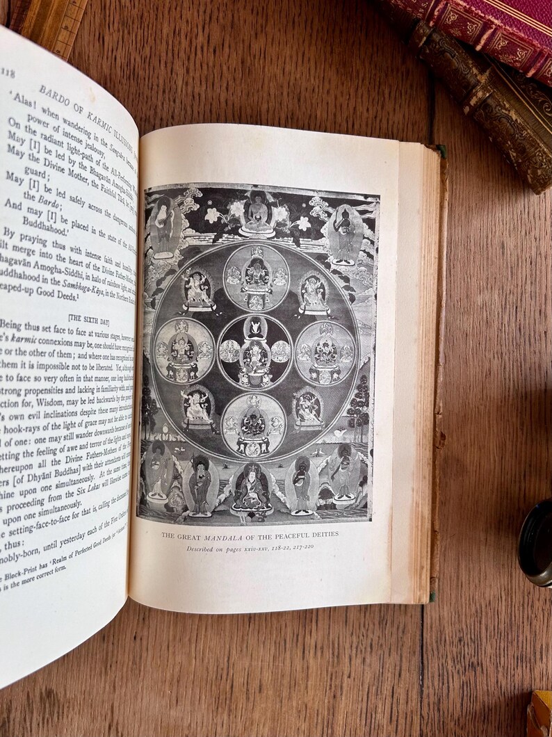 May include: A black and white illustration of a mandala with multiple deities in a circle. The text "The Great Mandala of the Peaceful Deities" is at the bottom of the image.